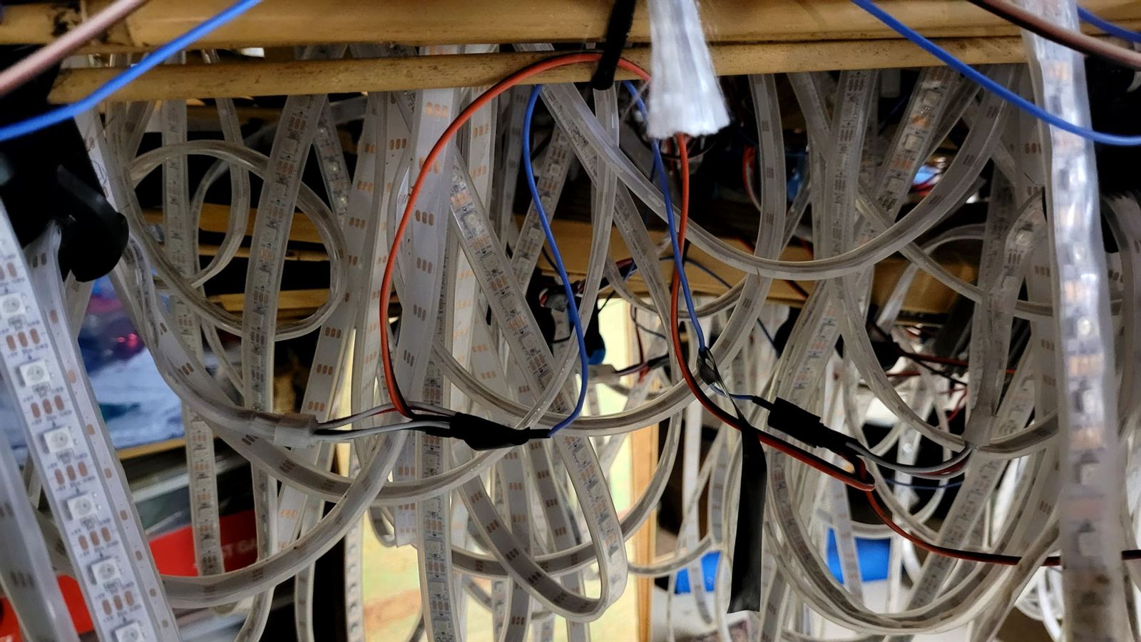 Bottom of an LED strip showing the blue data wire and newly added red and black power wires