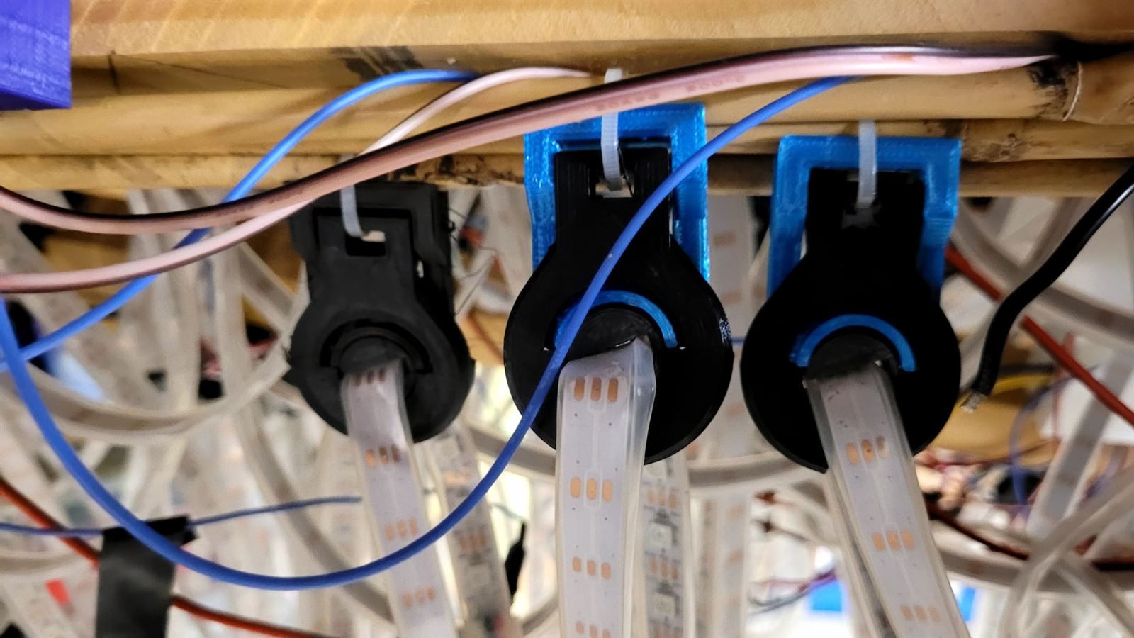 3D printed spaceship clips holding an LED strip to a bamboo support