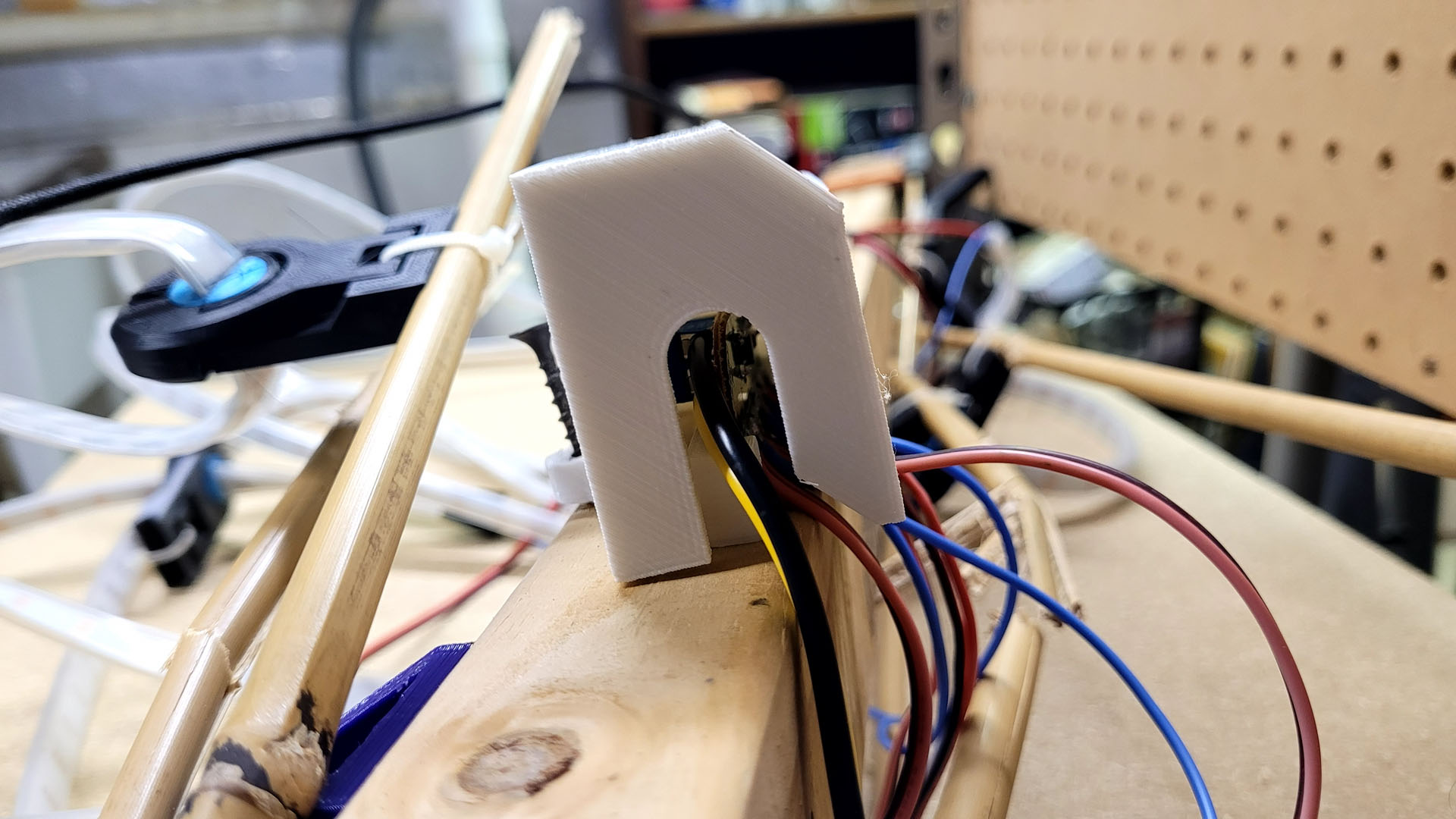 Side view of the 3D printed cap on a panel top, open on the side and bottom where the wires run out