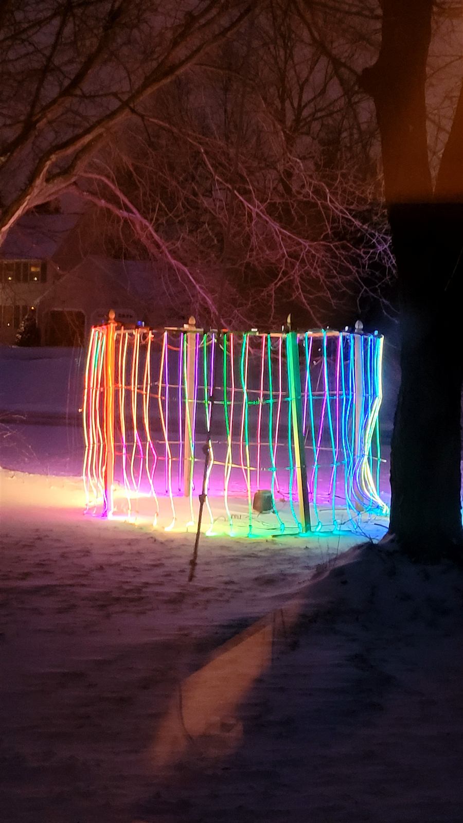 The Lightshow: a 20-foot ring of rainbow LED light columns glowing in a snowy front yard at night
